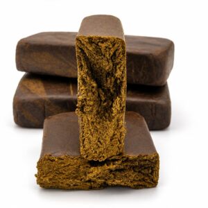 Static hash slab standing upright showing crumbly golden interior and dark pressed exterior